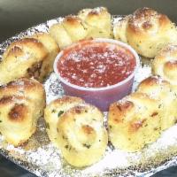 Garlic Knots · Fresh baked pizza dough tied in knot covered in garlic served with marinara sauce.