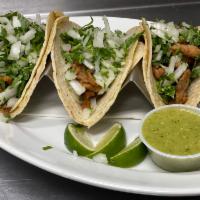 carne asada tacos (3) · marinated steak, on corn tortillas topped with onion and cilantro, served with verde tomatil...