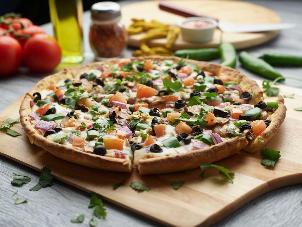 Indian Veggie Pizza Twist · This pizza has our signature creamy garlic sauce, fresh mushroom, fresh green pepper, juicy tomatoes, sliced black olives, crisp red onions fresh cut; garlic, ginger and green chillies, garnished with fresh cilantro. 