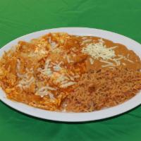 Chilaquiles · Refried beans, rice, tortilla chips sauteed with in a special sauce, eggs, cheese and sour c...