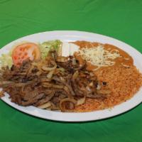 Bistec Encebollado Plate · Beef sauteed in onions and seasonings. Served with rice, refried beans, cheese, lettuce, gua...