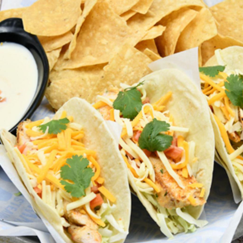 Blackened Chicken Tacos · Blackened chicken,  with green cabbage, cilantro, tomatoes, shredded cheese, and avocado lime dressing on flour tortilla. Served with queso and tortilla chips.