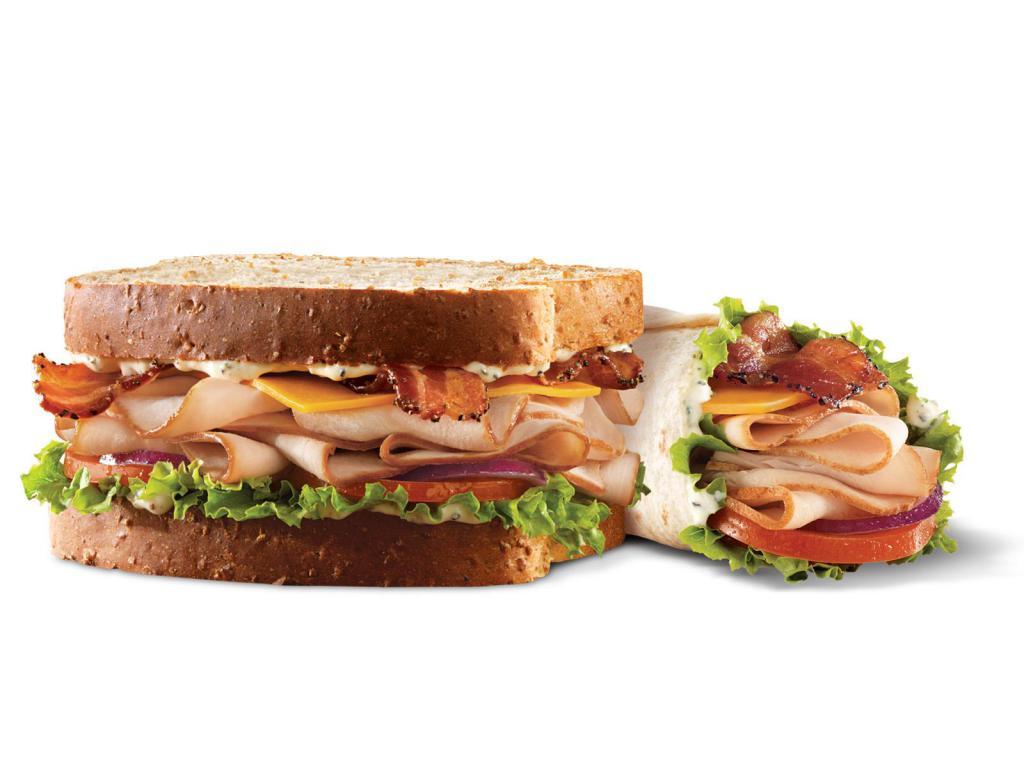 Market Fresh Roast Turkey Ranch & Bacon Sandwich Meal · Premium sliced turkey breast with pepper bacon, Cheddar cheese, green leaf lettuce, tomato, red onion and Parmesan peppercorn ranch sauce on sliced honey wheat bread. Meal includes choice of side and drink. Visit arbys.com for nutritional and allergen information.