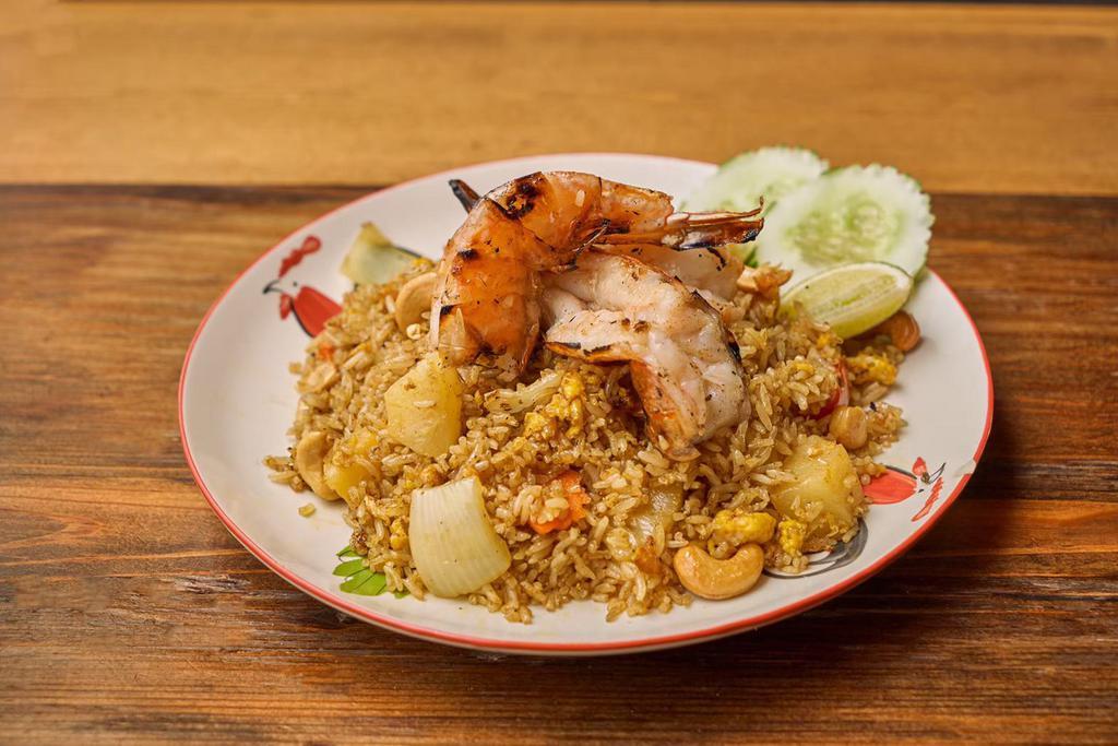 Khao Phad Sup Pa Rod · Pineapple fried rice with yellow curry powder, cilantro, cashew nut, carrot, egg and onion.