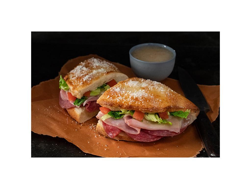 Italian Deli Boat · Calzone style sandwich baked with pizza dough stuffed with ham, salami, provolone, lettuce & tomatoes. Served with a side of Italian dressing. (10