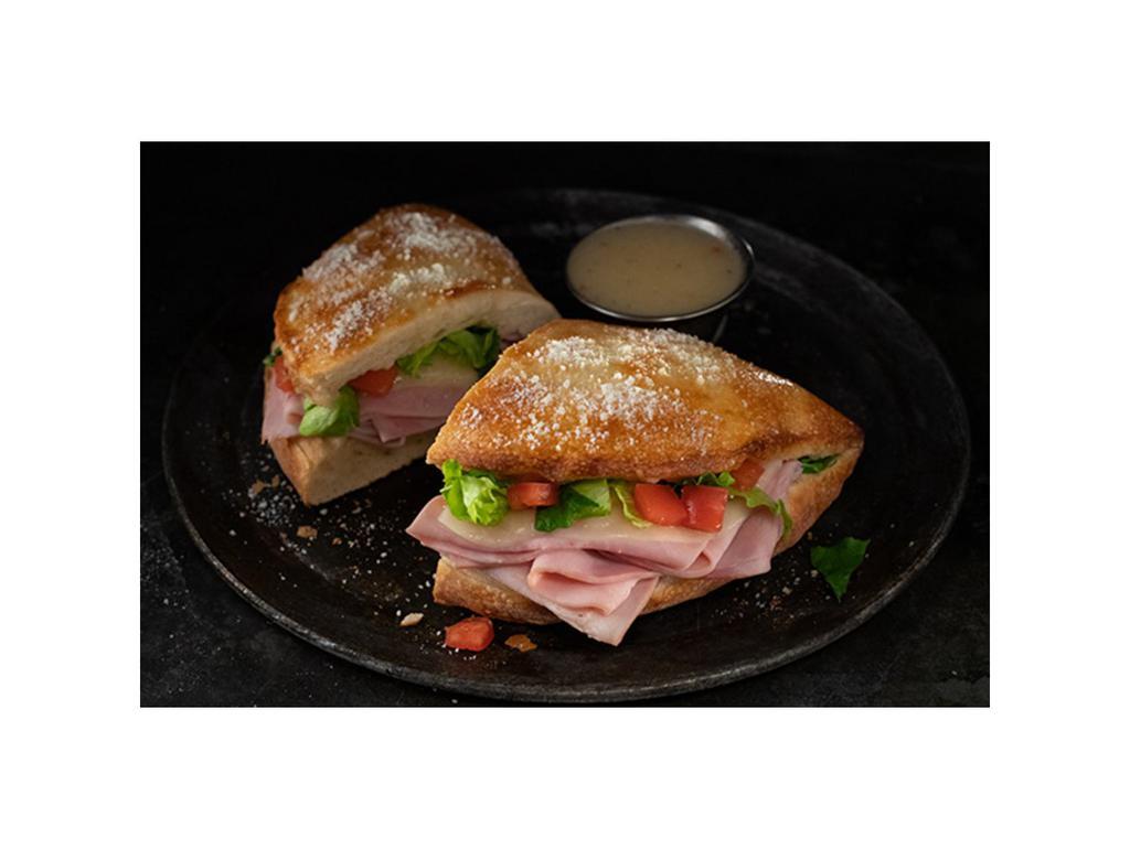 Ham and Cheese Deli Boat · Calzone style sandwich baked with pizza dough stuffed with ham, provolone, lettuce & tomatoes. Served with a side of Italian dressing. (10