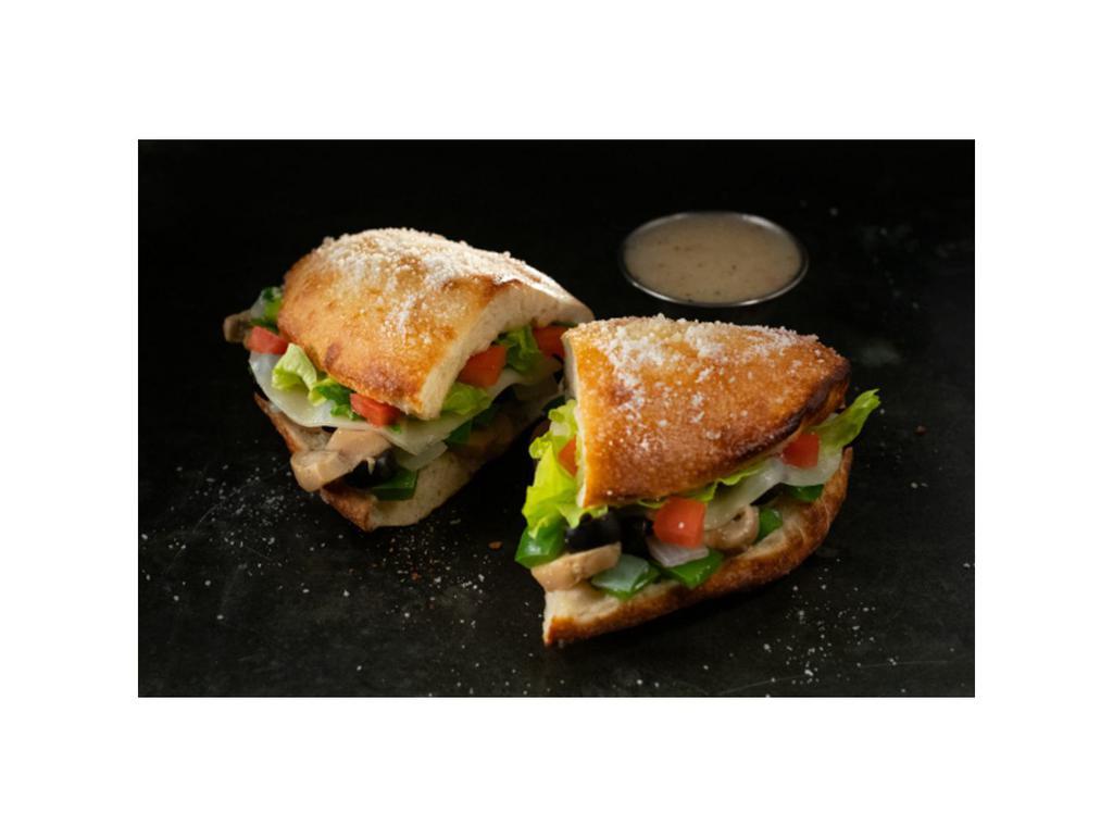 Veggie Deli Boat · Calzone style sandwich baked with pizza dough stuffed with provolone, onions, green peppers, mushrooms, black olives, lettuce & tomatoes, topped with butter & romano served with a side of Italian dressing. (10