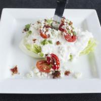Wedge Side Salad · Iceberg, blue cheese crumbles, bacon, green onions, tomatoes, topped with house made blue ch...