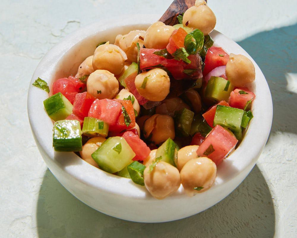 Side Chickpea Salad · Cooked chickpeas mixed with freshly chopped tomato, cucumber, onion, mint, parsley, and cilantro dressed in our lemon vinaigrette.