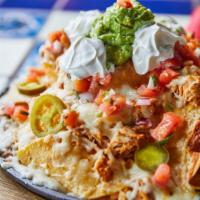Loaded Skillet Nachos · You ready for this? House-fried chips over a bed of refried beans, double layered with chick...