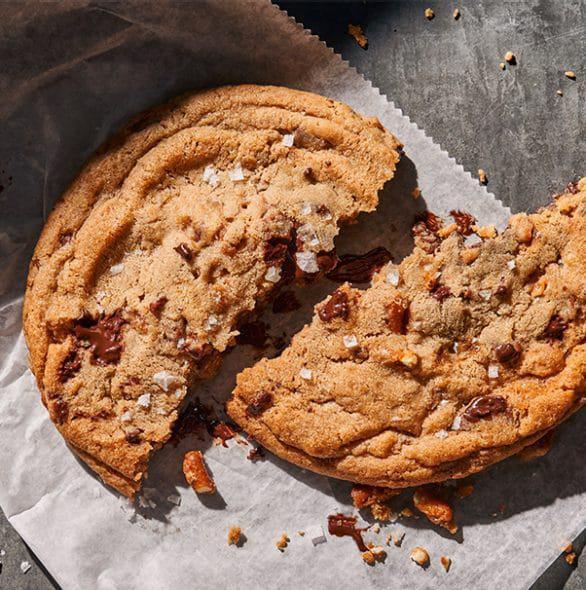 Kitchen Sink Cookie · 800 Cal. A salty, chocolaty, caramel confection big enough to share.  A large cookie with semi-sweet chocolate, milk chocolate, caramel pieces, pretzels and then topped with flake salt. Allergens: Contains Wheat, Soy, Milk, Egg