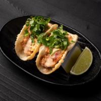 Spicy Tuna Mini Tacos · Spicy tuna in a crispy wonton taco shell wrapped with cilantro.