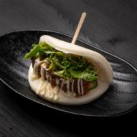 Jinya Bun · Steamed bun stuffed with slow braised pork chashu, cucumber and baby mixed greens served wit...
