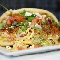 Blackened Fish Taco · 6 ounces of Mahi with our mildly spicy blackening seasoning. Served on a pita shell atop hou...