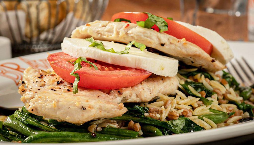 Chicken Caprese · Pan-seared chicken, spinach, tomatoes, zucchini, mozzarella, orzo, farro, pesto vinaigrette, balsamic glaze
