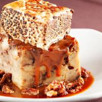 ROCKY ROAD BREAD PUDDING · Butterscotch bread pudding with chocolate chips in a caramel sauce, topped with candied waln...