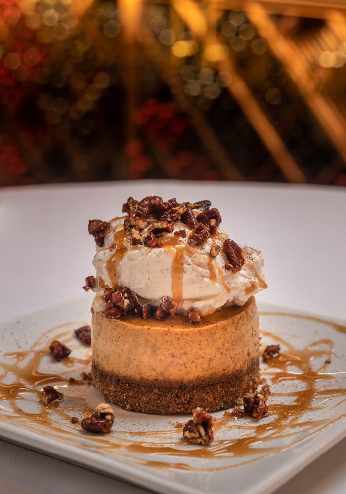 SEASONAL CHEESECAKE · Creamy pumpkin-spiced cheesecake with
pecan ginger snap crust, vanilla cream
and salted caramel drizzle