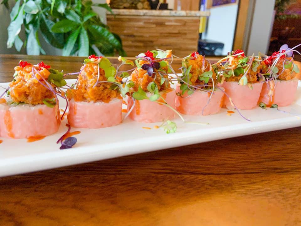 51. Sweet Heart Roll · Salmon and avocado, pink soy wrap, topped spicy tuna, micro green, tobiko.