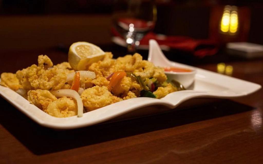 Calamari · Fried calamari tossed with bell peppers and jalapeno, seasoned with lemon pepper and served with chili garlic sauce.