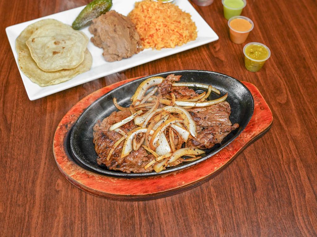 Arrachera Platter · Mexican style marinated grilled steak. Served with rice, refried beans, tortillas, and a pinch of fresh made guacamole.