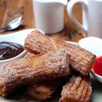 Churros · Hot Mexican doughnuts dusted with sugar 
and cinnamon. Served with dark chocolate  
and ra...