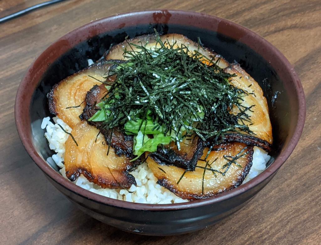 Chashu Bowl · Slices of grilled chashu pork served over rice with green onions,