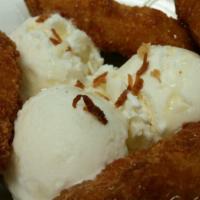 Fried Banana with Ice Cream · Battered fried banana with coconut ice-cream topped with honey and baked coconut flakes.