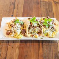 Short Rib Breakfast Tacos · Griddled short rib, hash browns, fire roasted green chilis, scrambled eggs, cheese and clian...