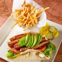 Tempting Tempeh Sandwich · Smoky maple tempeh, crisp romaine, tomatoes and avocado with creamy chive sauce on a greek f...
