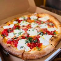 Margherita Pizza · Thin crust pizza with chunks of tomato, fresh mozzarella, basil, and olive oil.