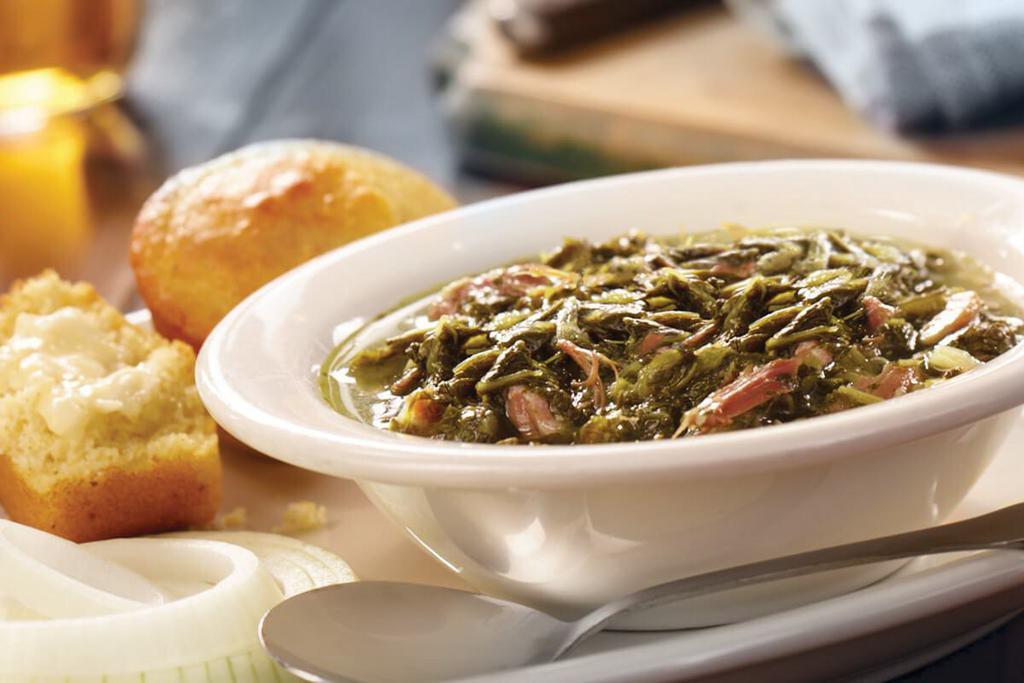 Bowl of Turnip Greens · Turnip Greens simmered with Country Ham and served with an onion slice and vinegar. Served with  hand-rolled Buttermilk Biscuits (160 cal each) or Corn Muffins (210 cal each) and real butter.

