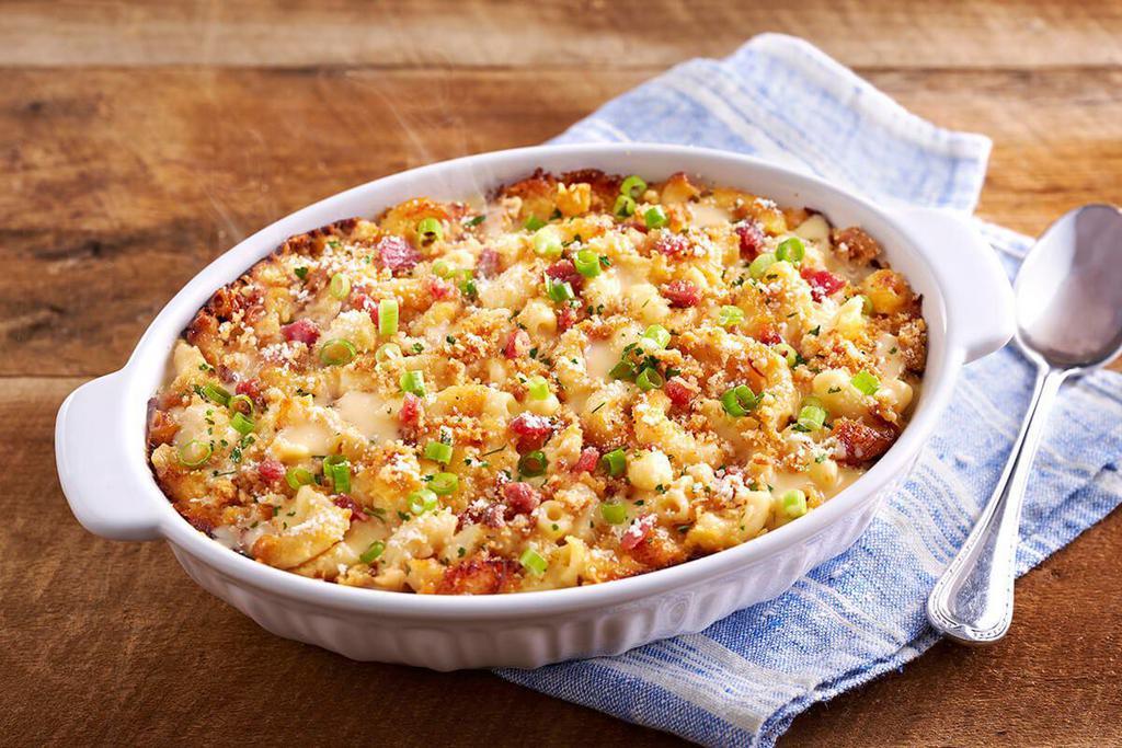 Bacon Mac n' Cheese · Our creamy macaroni n’ cheese comes topped with crispy bacon bites, parsley, green onions, and parmesan cheese.


