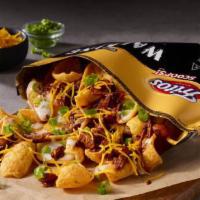 Brisket Chili Walking Taco · Texas-style brisket chili over a bed of Fritos, topped with creamy Poblano Queso, shredded c...