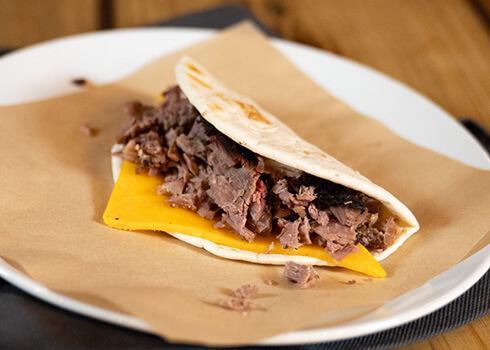 Brisket & Cheese Taco · Slow smoked chopped brisket, cheddar cheese on a flour tortilla
