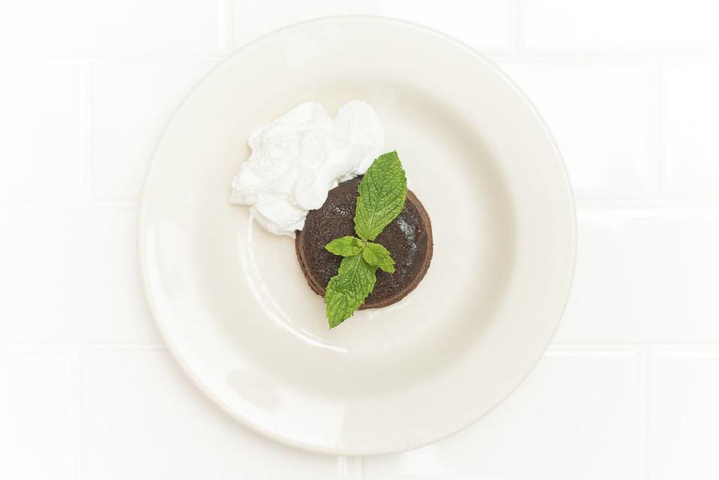 Chocolate Tartufo · Warm triple chocolate cake with a chocolate truffle center, served with whipped cream. 