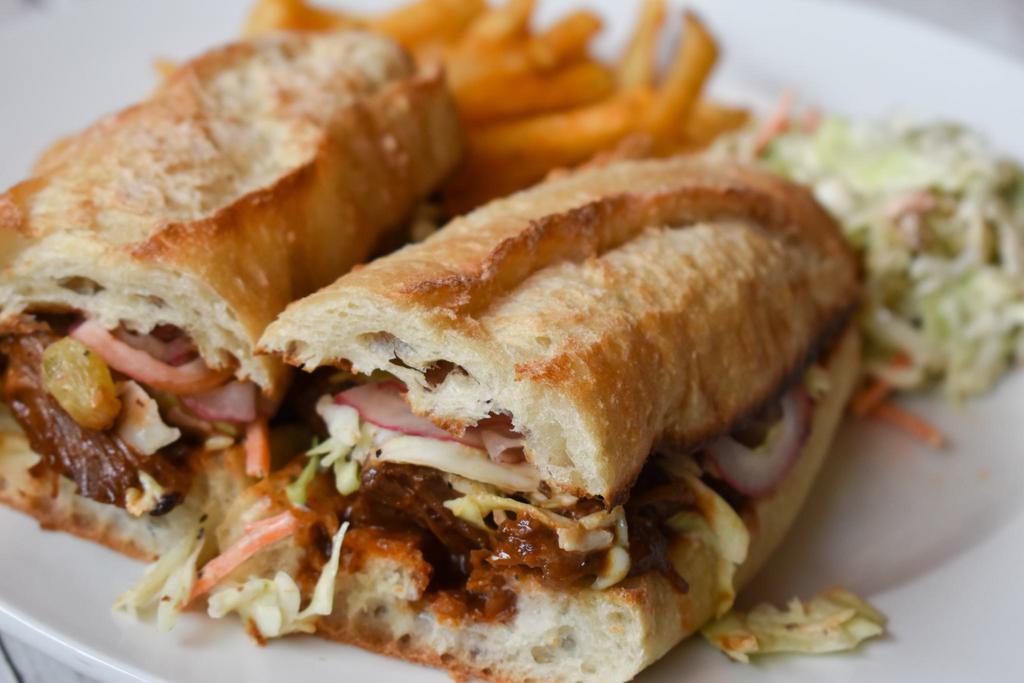 Short Rib Sandwich · Sourdough baguette, BBQ sauce, coleslaw, pickled red onion, served with french fries and coleslaw. 