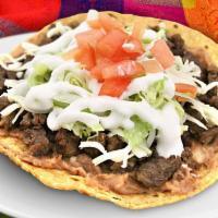 Tostada · Thin toasted tortilla with your choice of meat topped with beans, lettuce, tomato cheese and...