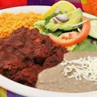 Guisado de Puerco Dinner · Pork slowly cooked in a red chile guajillo sauce.