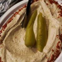 Hummus · Puree of chickpeas and spices garnished with paprika and pickles.