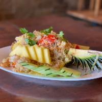 Pineapple Fried Rice · Pineapple fried rice with egg, tomatoes, green onion, yellow onion, cilantro, raisins, cashe...