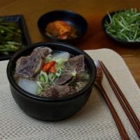 GALBI TANG · Long simmered short rib stew with vegetables and noodles in a stone pot.