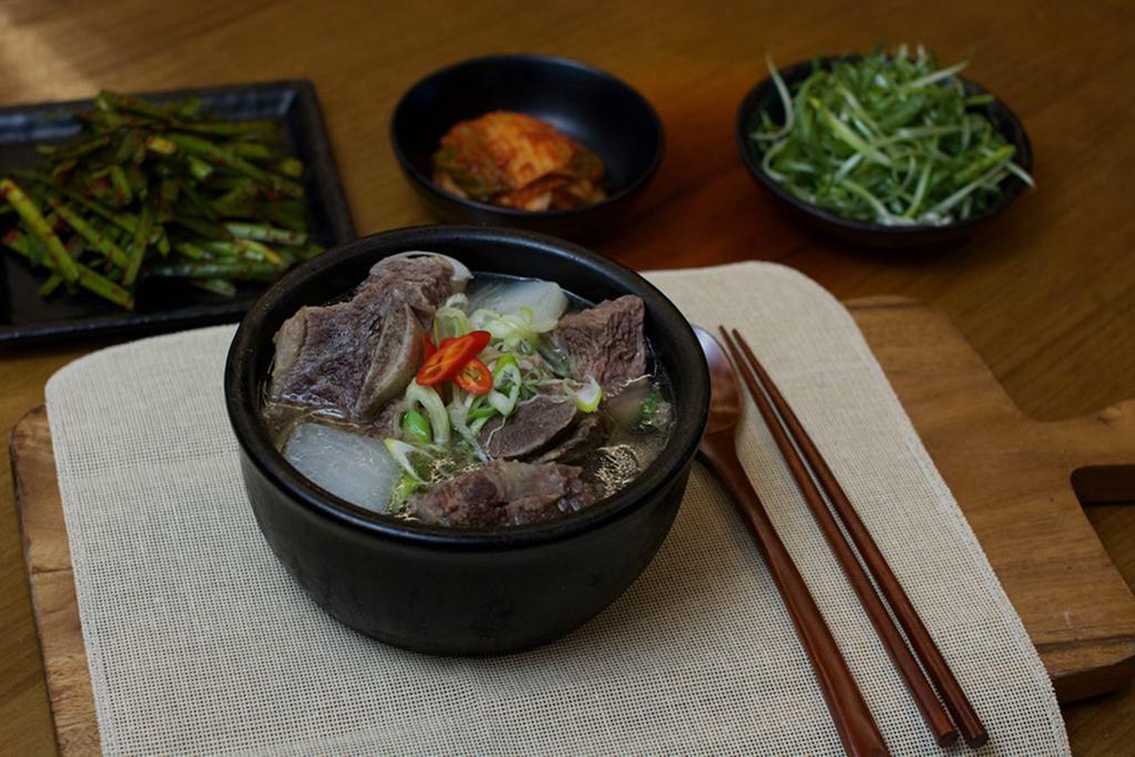 GALBI TANG · Long simmered short rib stew with vegetables and noodles in a stone pot.