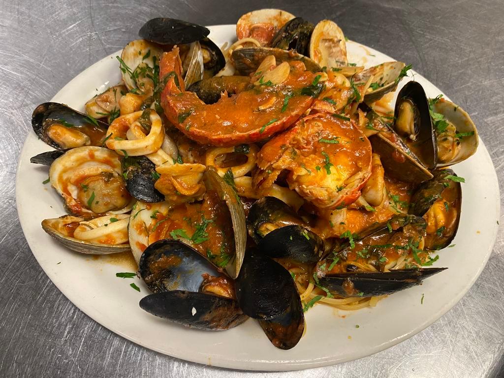 Seafood Combination · Lobster tail, clams, mussels, calamari, and shrimp over linguine.