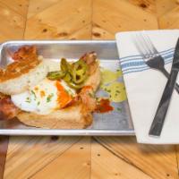 Eggs In Jail · Poached eggs incarcerated in a circle of bacon and toast with hollandaise sauce over toasted...