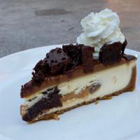 Caramel Brownie Bite Cheesecake Slice · white chocolate, dulce de leche caramel, brownie chunks, whipped cream