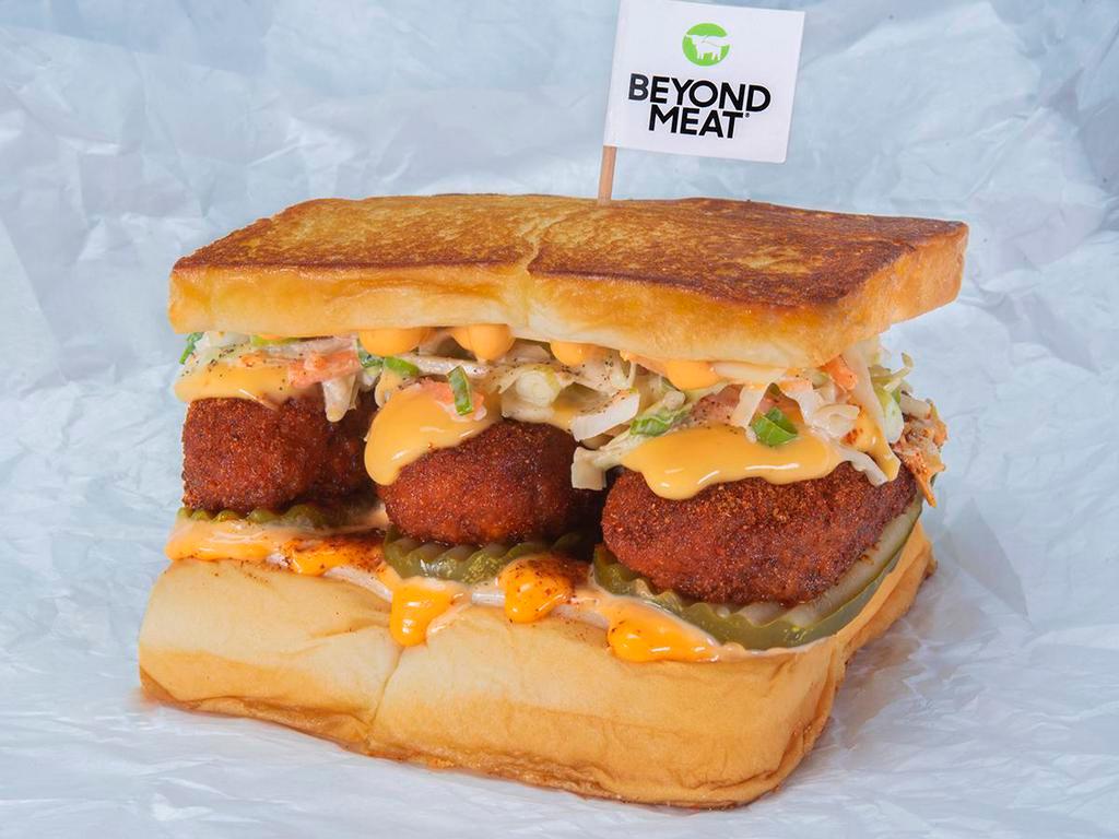 Beyond® The Cheesy Chick · Two crispy fried Beyond® tenders, spiced to your liking, Plain, Nashville Hot or Nashville Hotter with dill pickle slices, slaw, white American cheese, cheese sauce and chipotle Aioli; served on King's Hawaiian rolls