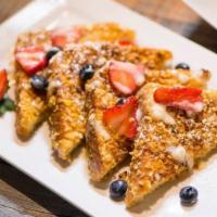 Gocha’s Krunch-tastic · Crunchy battered French toast with mixed berries powdered sugar and our house vanilla bean s...