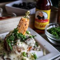 Salmon Grit Cake · Salmon bite over decadent fried golden brown grit cake topped with jalapeno, cheese and mush...