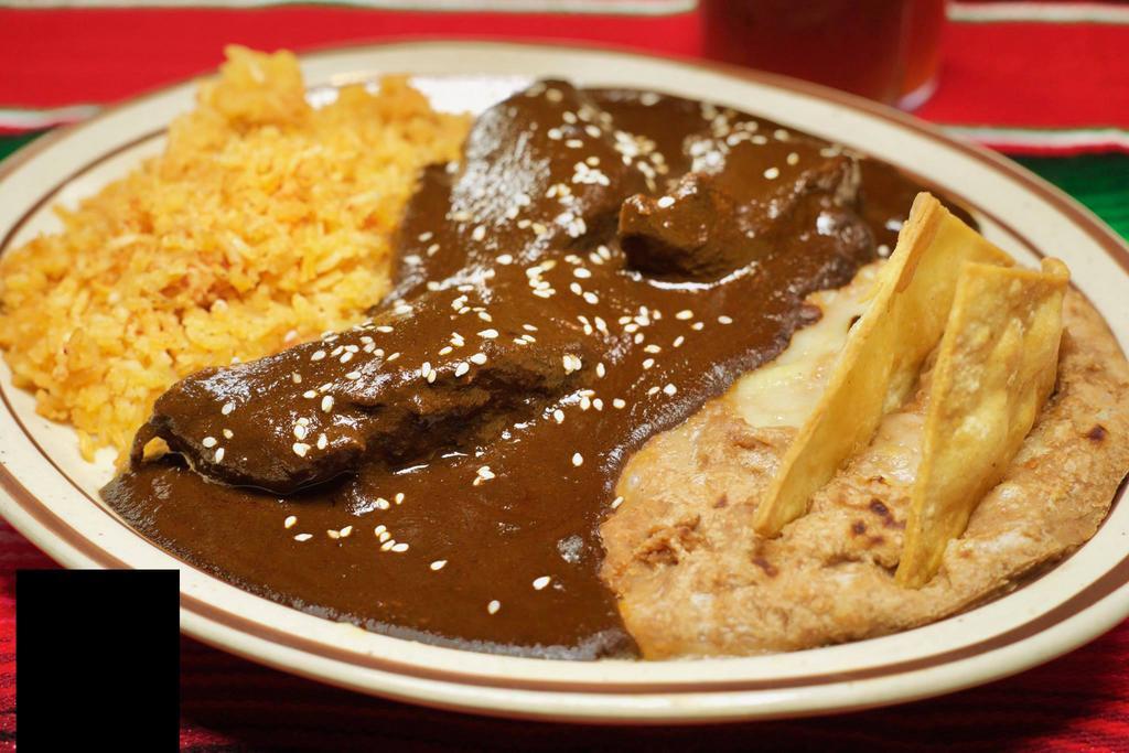 Chicken Mole · A mild sauce composed of chocolates, ground chile peppers and spices, served over breast of chicken with refried beans, Spanish rice and tortillas. Served with sopapillas with honey.