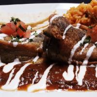 Chiles Rellenos · Poblano peppers (2) stuffed w/ cheese on house made roasted tomato salsa. Served with Rice a...